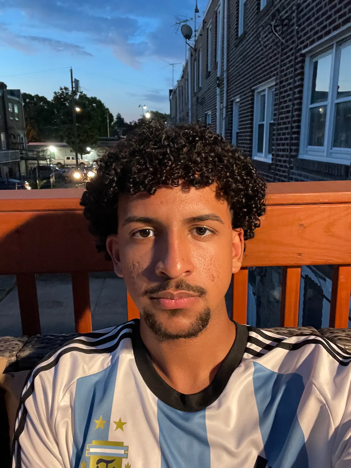 Ian Catalino-Vasquez ’28 sitting on a porch at night.