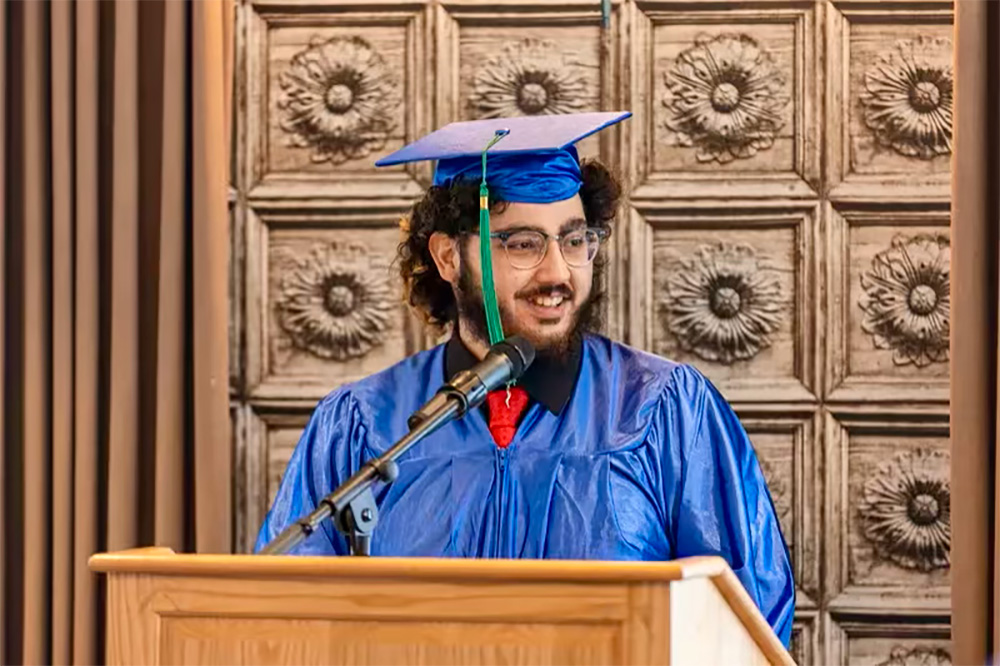 Mohamed Elbahwati speaking at his graduation ceremony.