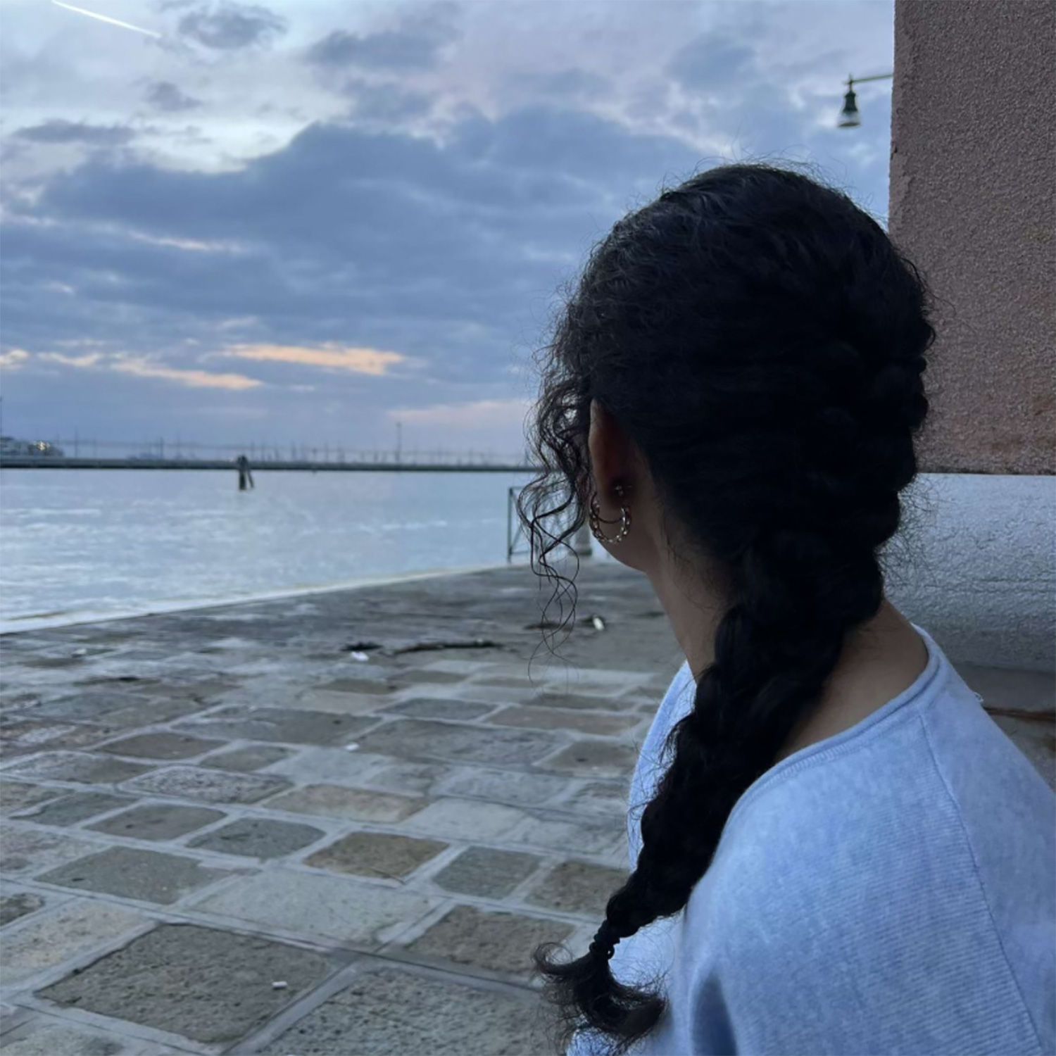 Gauri Chopra looking out at the ocean and a bridge in the distance.