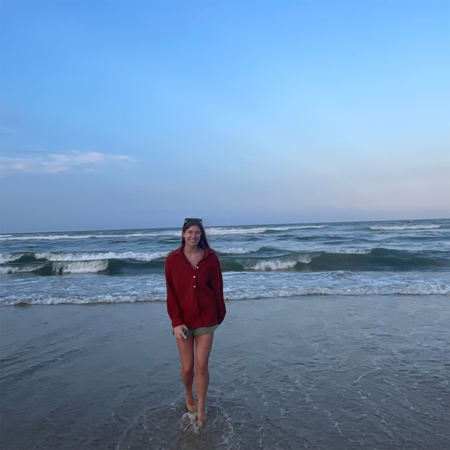 Grace Caldwell walking on the beach with the ocean in the background.