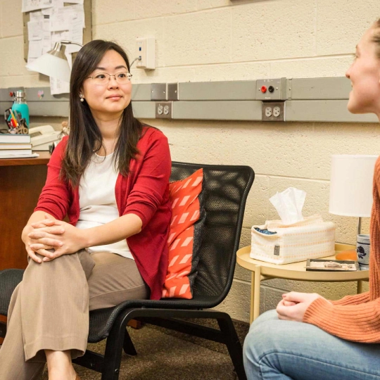 Dr. Cathy Lee talks with a counseling student.