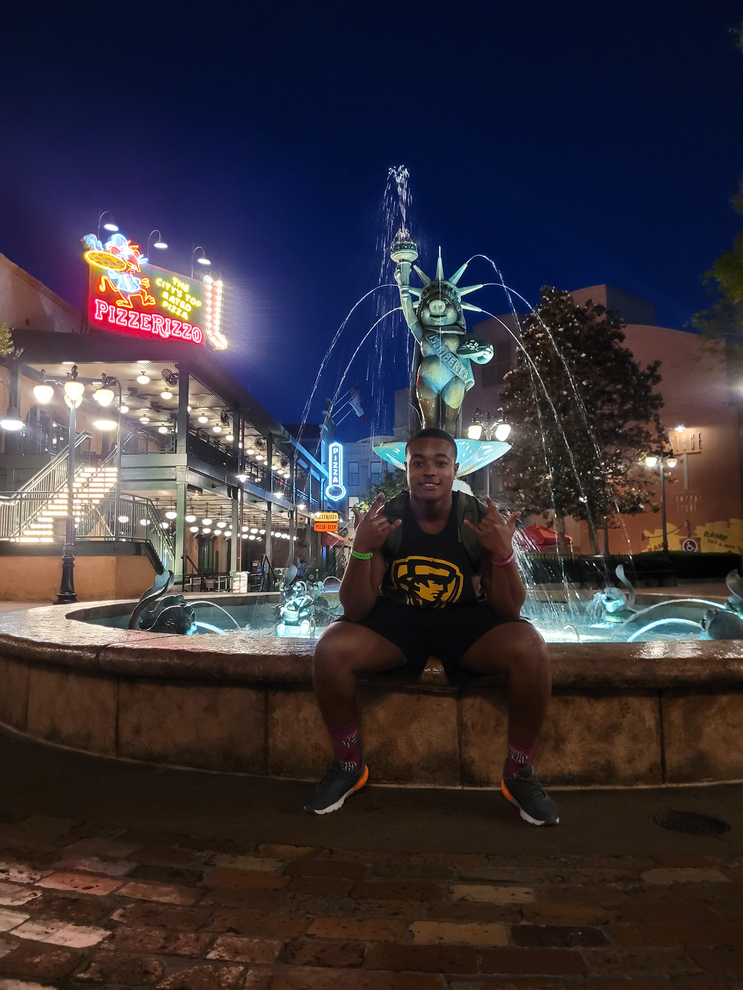 Aaron Lemons ’28 sitting on the ledge of a fountain.