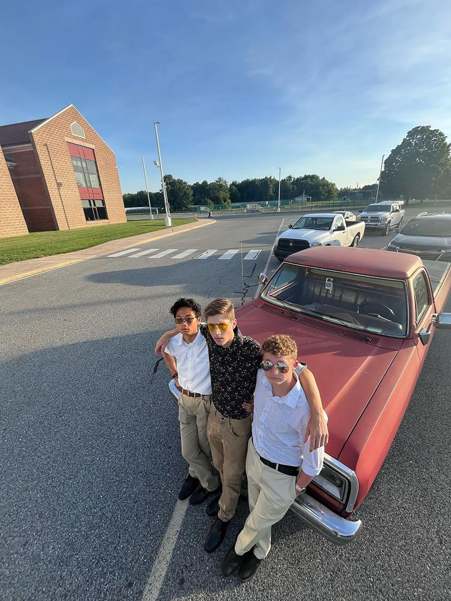 Jack Riley ’28 leaning on the hood of a truck with friends.