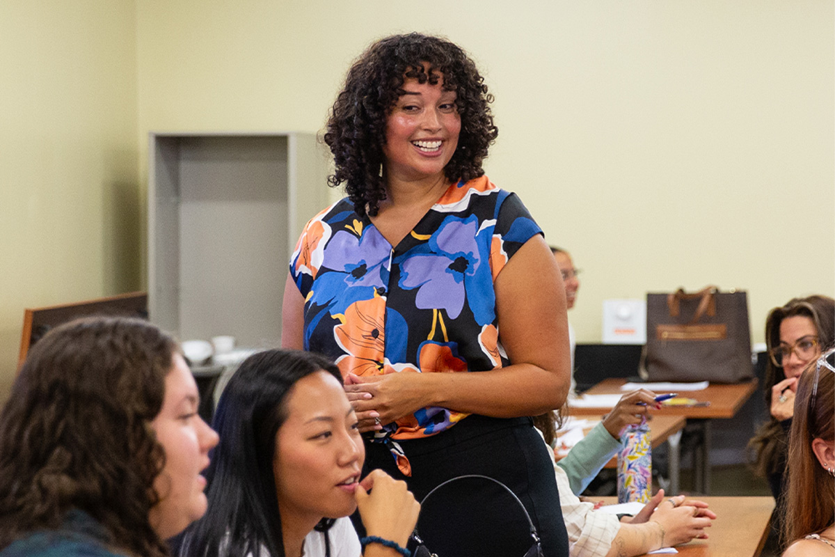 Grad student teaching fellow students in a classroom.