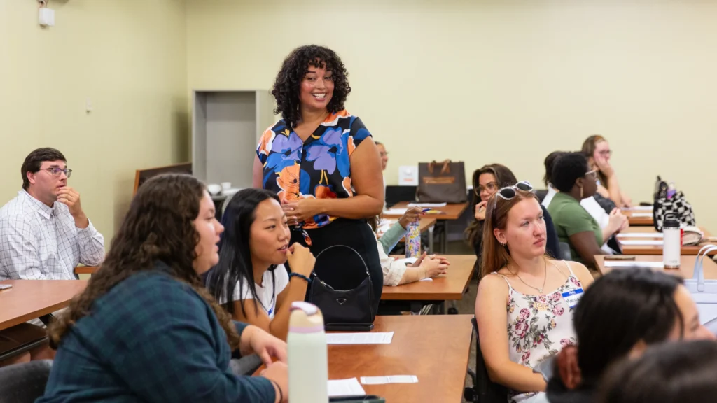 Students and a professor talk during their graduate counseling orientation.