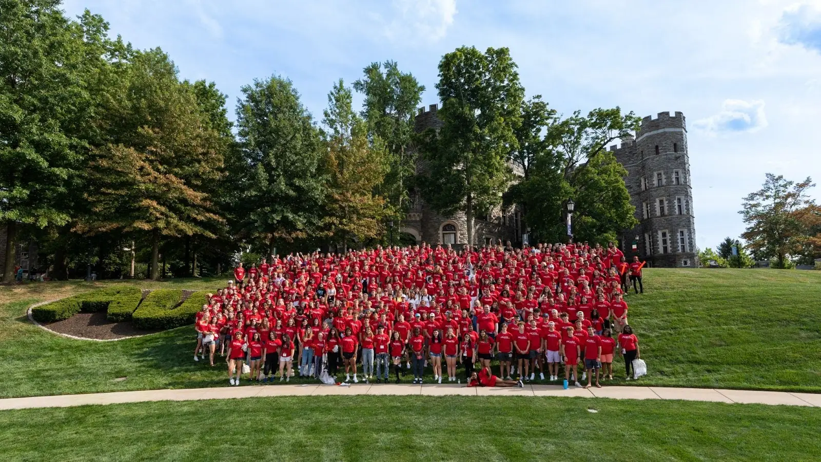 Arcadia students wearing Arcadia shirts in front of the Grey Towers Castle.