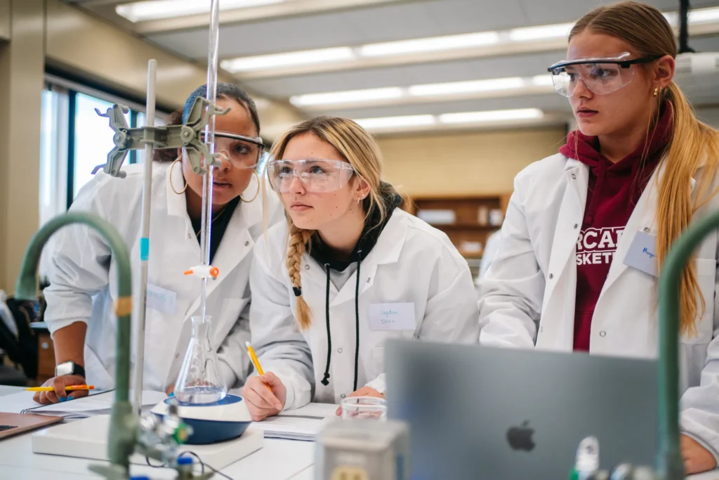 Three biology students work in a lab.