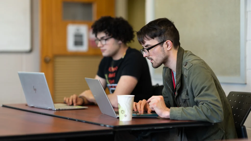 English students work on their laptops.