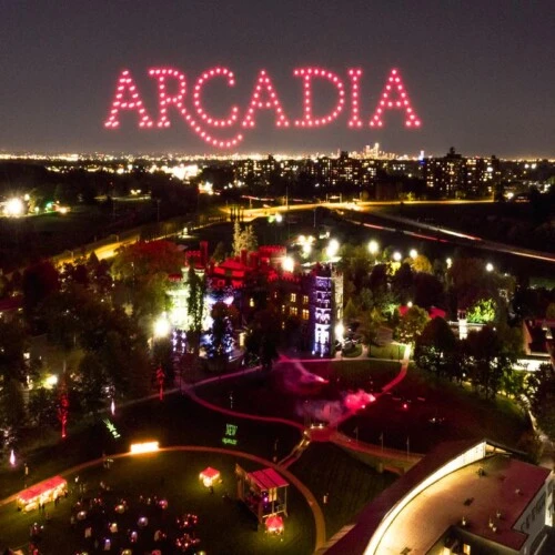Drones light up the sky over campus spelling out the name "Arcadia" in red lighting.