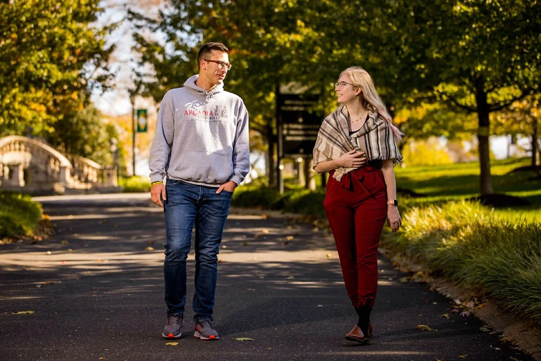 Two students walking on Arcadia's campus outside.