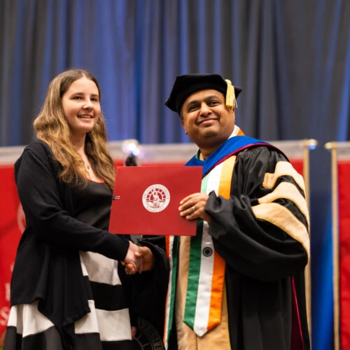 A professor hands a student an award at the 2023 Honors Convocation