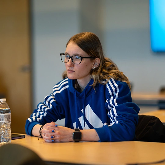 A student listens closely to a lecture during class at the School of Global Business.