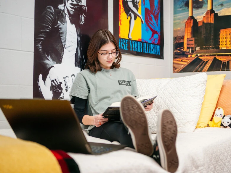 An undergraduate reads in her dorm room.