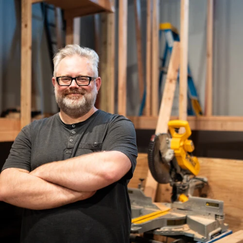 Director Matthew Borgen standing in front of a saw inside Spruance Gallery.