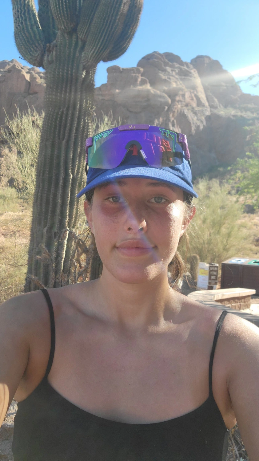 Chana Rothschild in the desert with a cactus and mountains behind her.