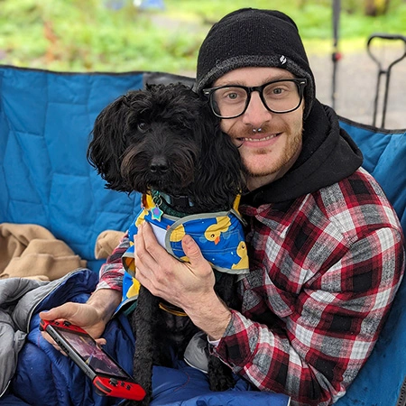 Matthew Rausch, a graduate student at Arcadia, and his small black dog.