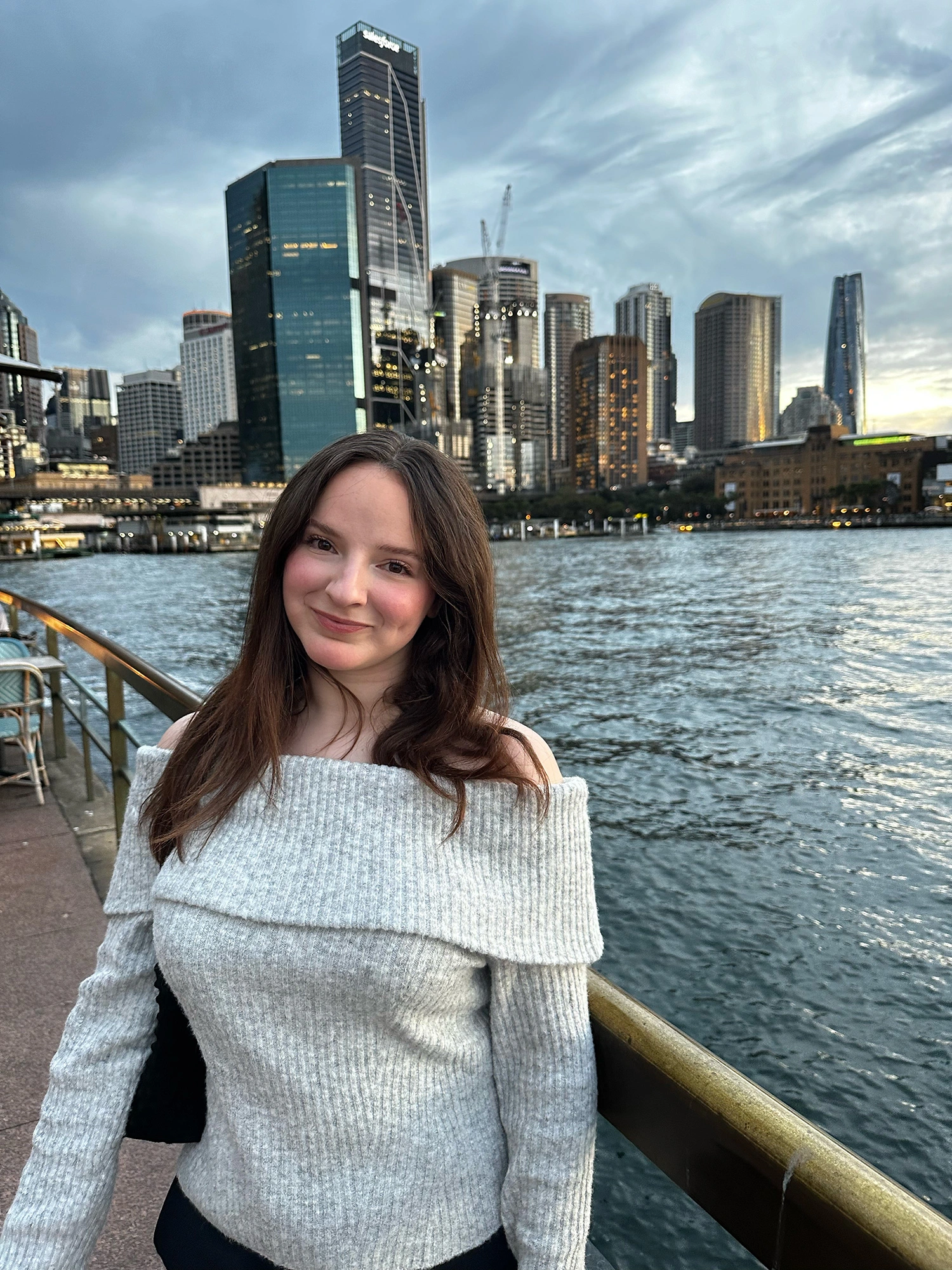 Sydney Boudreau standing in front of a city skyline.