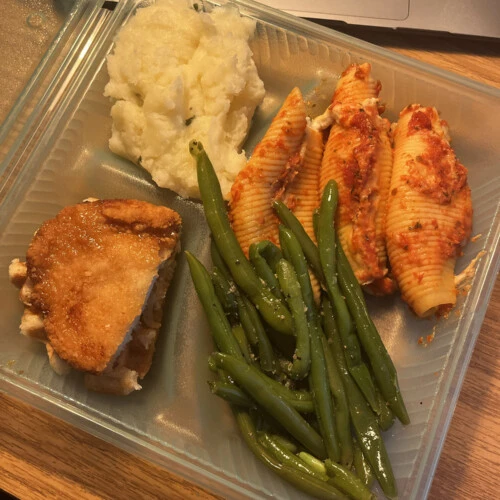 A meal in a dining hall to-go container.