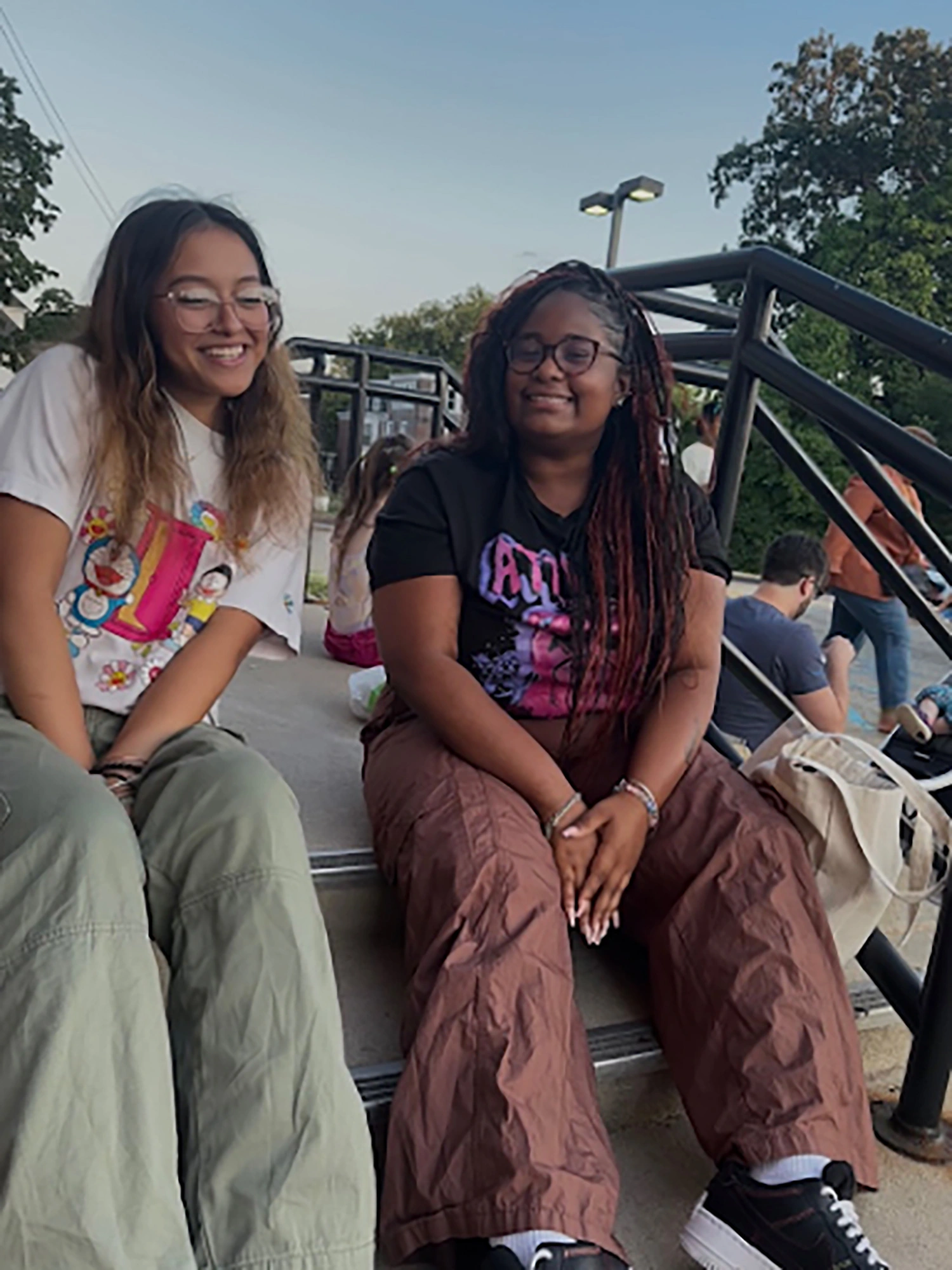 Makiyah and her friend sitting on a step.