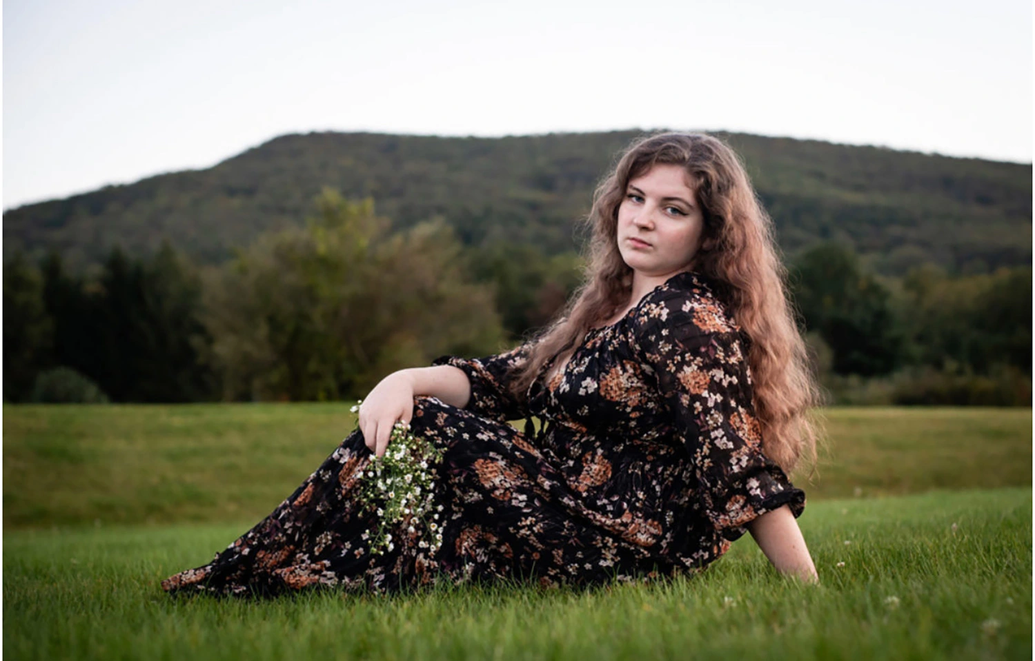 Elizabeth Cogan ’28 sitting in a field.