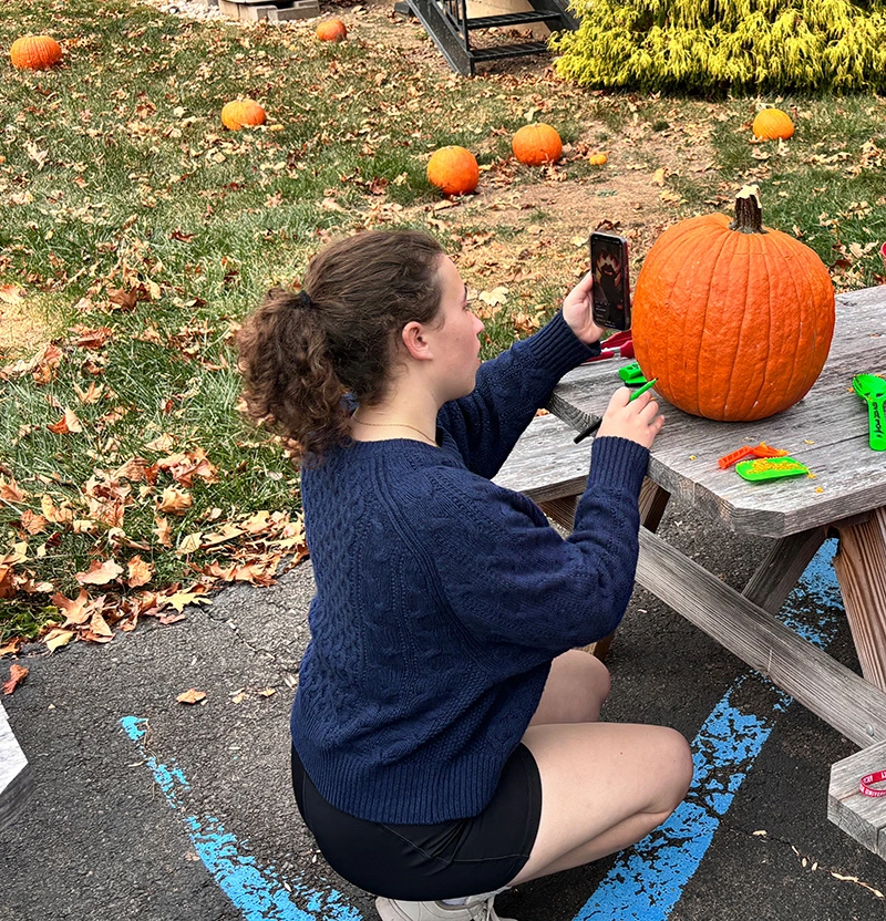 Student carving pumpkin