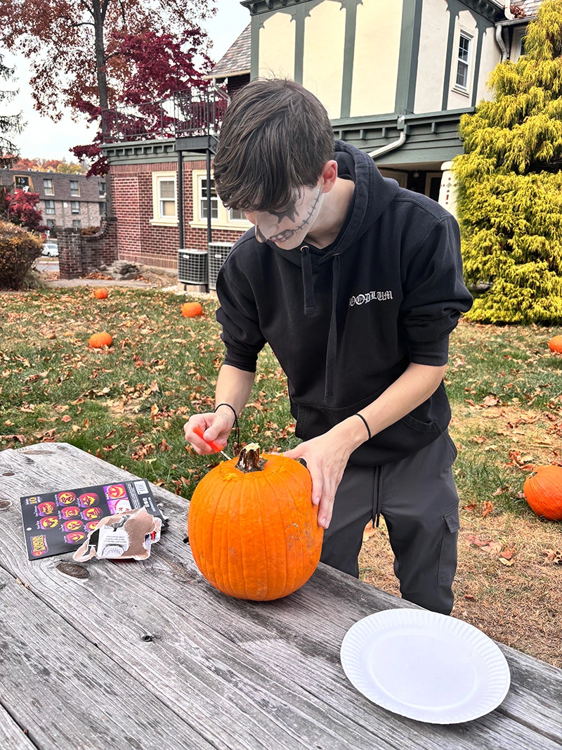 Student carving pumpkin