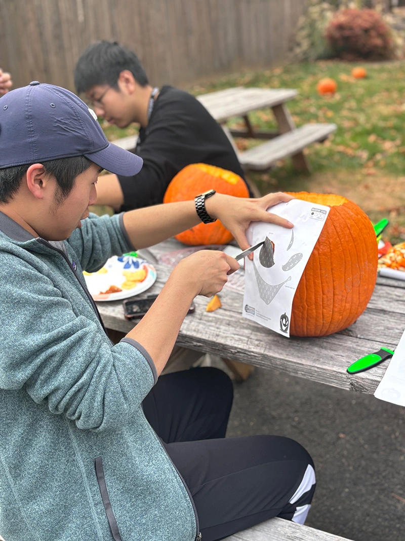 Chayhok Chhor works on carving a spooky design into his pumpkin