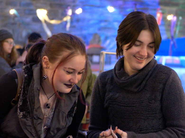 Two undergraduate students look at an event table during Get Lit on campus.