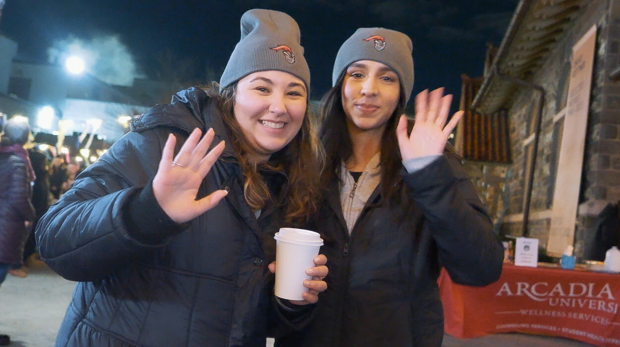 Two women give a friendly wave and are bundled up in winter coats and hats as they attend the Get Lit event at Arcadia.