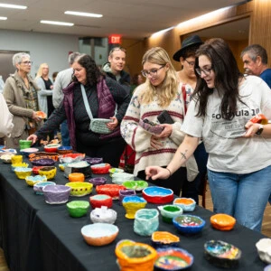 Students looking at the bowls at Empty Bowl.