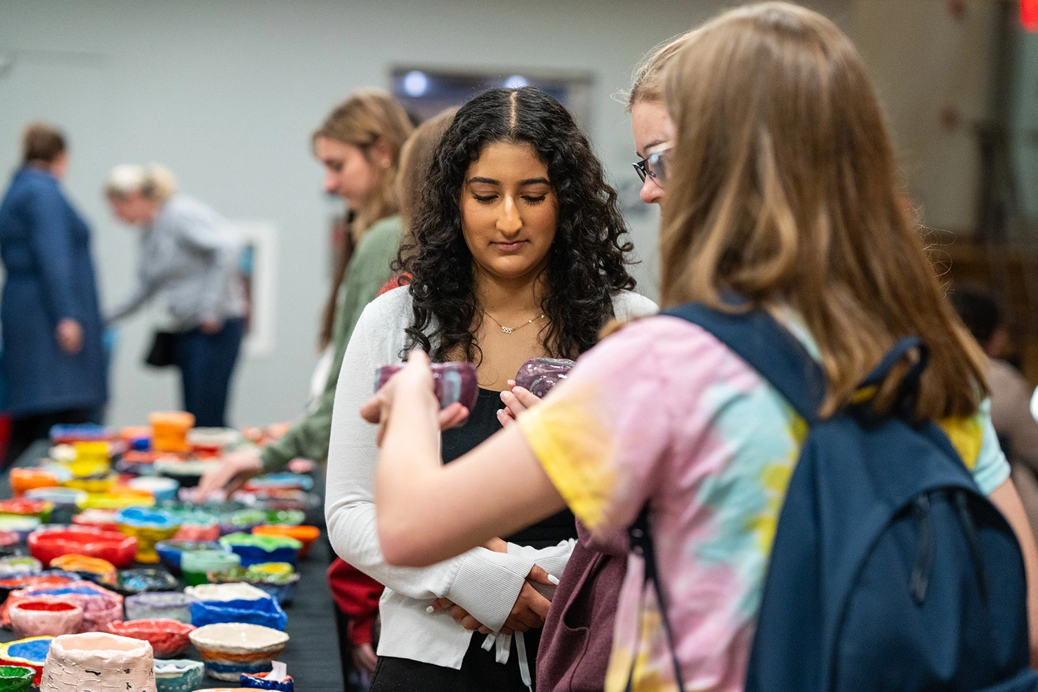 Students looking at the bowls at Empty Bowl.