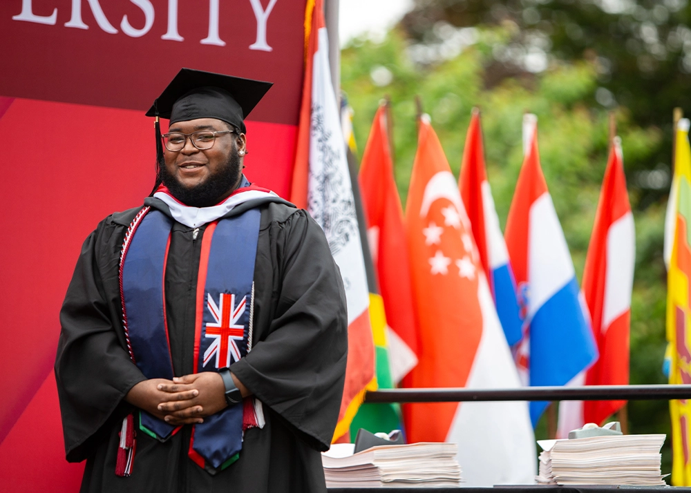 Arcadia student standing on the stage at graduation.