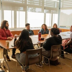 People gathered around the conference room table in the Campus Life office