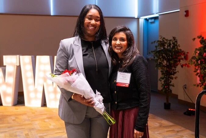 Aliyah Abraham '17 holds flowers while standing next to Arcadia Ambassador Paayal Nair at the 2024 Women Who Lead Forum