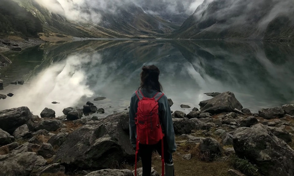 A person looking a panorama of mountain and lake