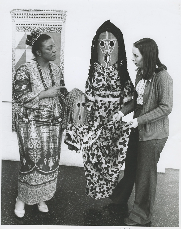 Faith Ringgold standing with a student and a sculpture in the exhibition space.