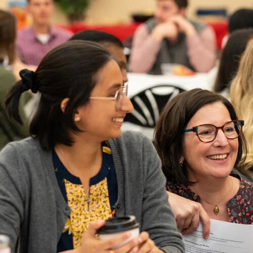 Students sit around a big round table and talk to Dené Mitchell, MPH Courses and Student Engagement Manager, during interprofessional education day '24.