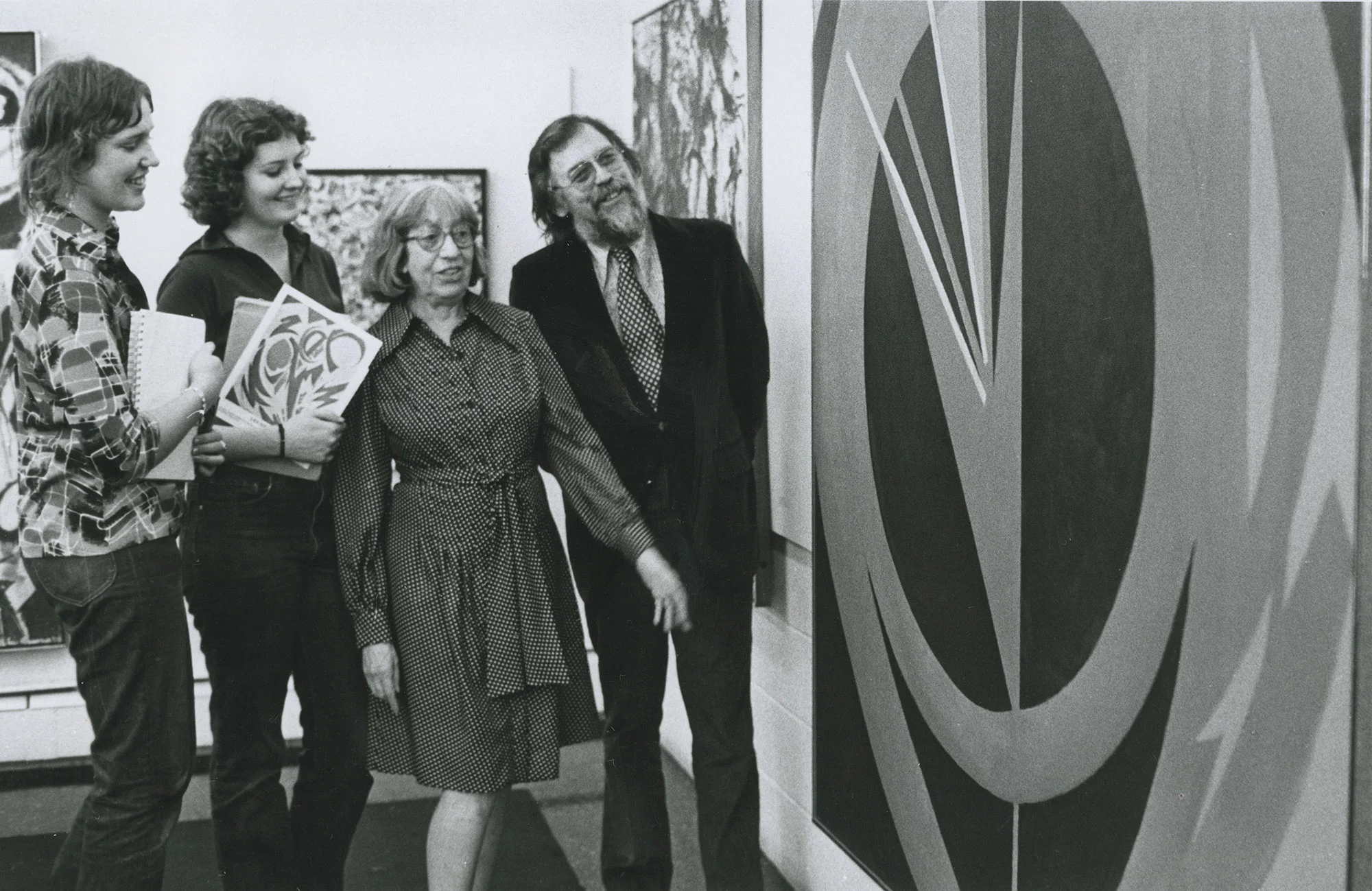 Lee Krasner, artist, and others standing in front of a large painting.