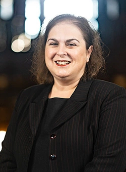 Nicole Steiner, Associate Vice President for Alumni Engagement and Annual Giving stands in grand stairway of the Castle.