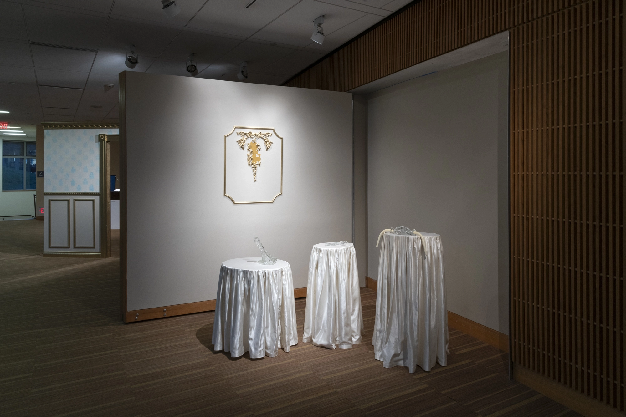 Installation view of "Kitty Rauth: The Mirror Room." Three tables with a folding wall behind them.