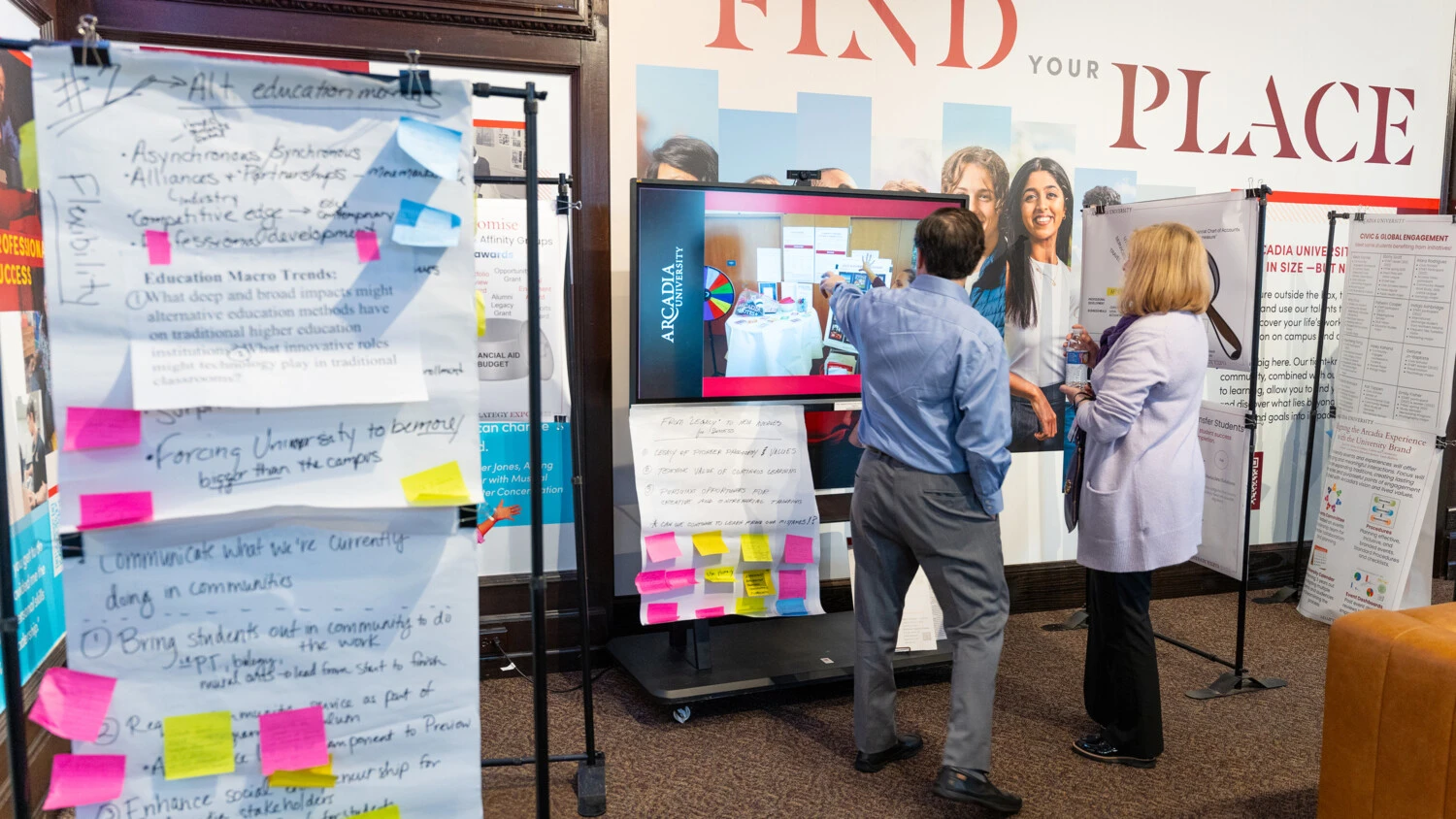 Two people look at a display illustration during the Gallery Walk and idea sessions.