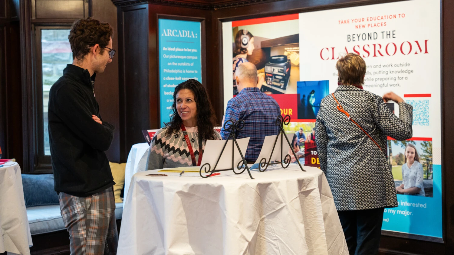 A small crowd gathers around displays during the Gallery Walk and idea event.