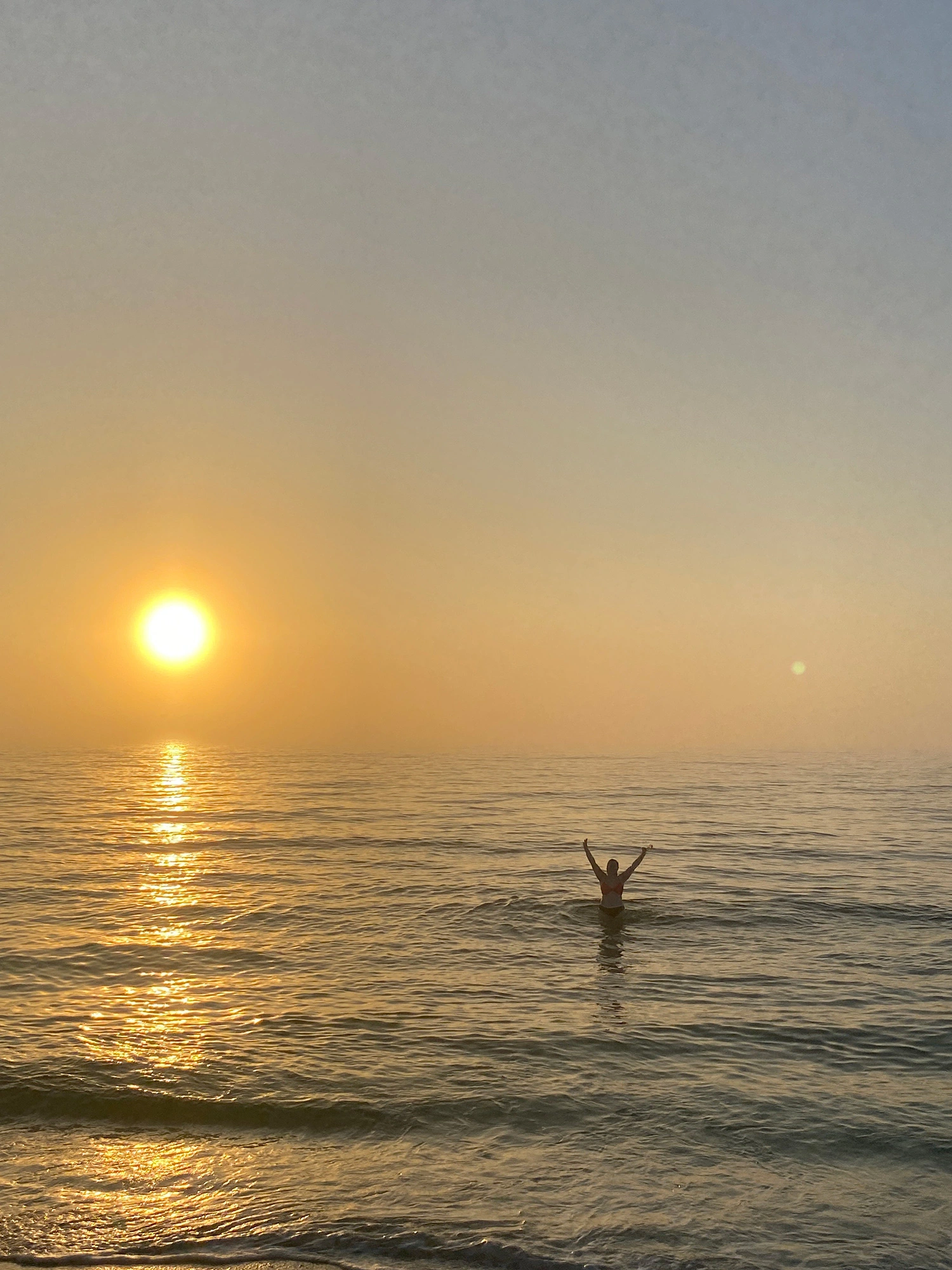 Zara in the ocean during a sunset.