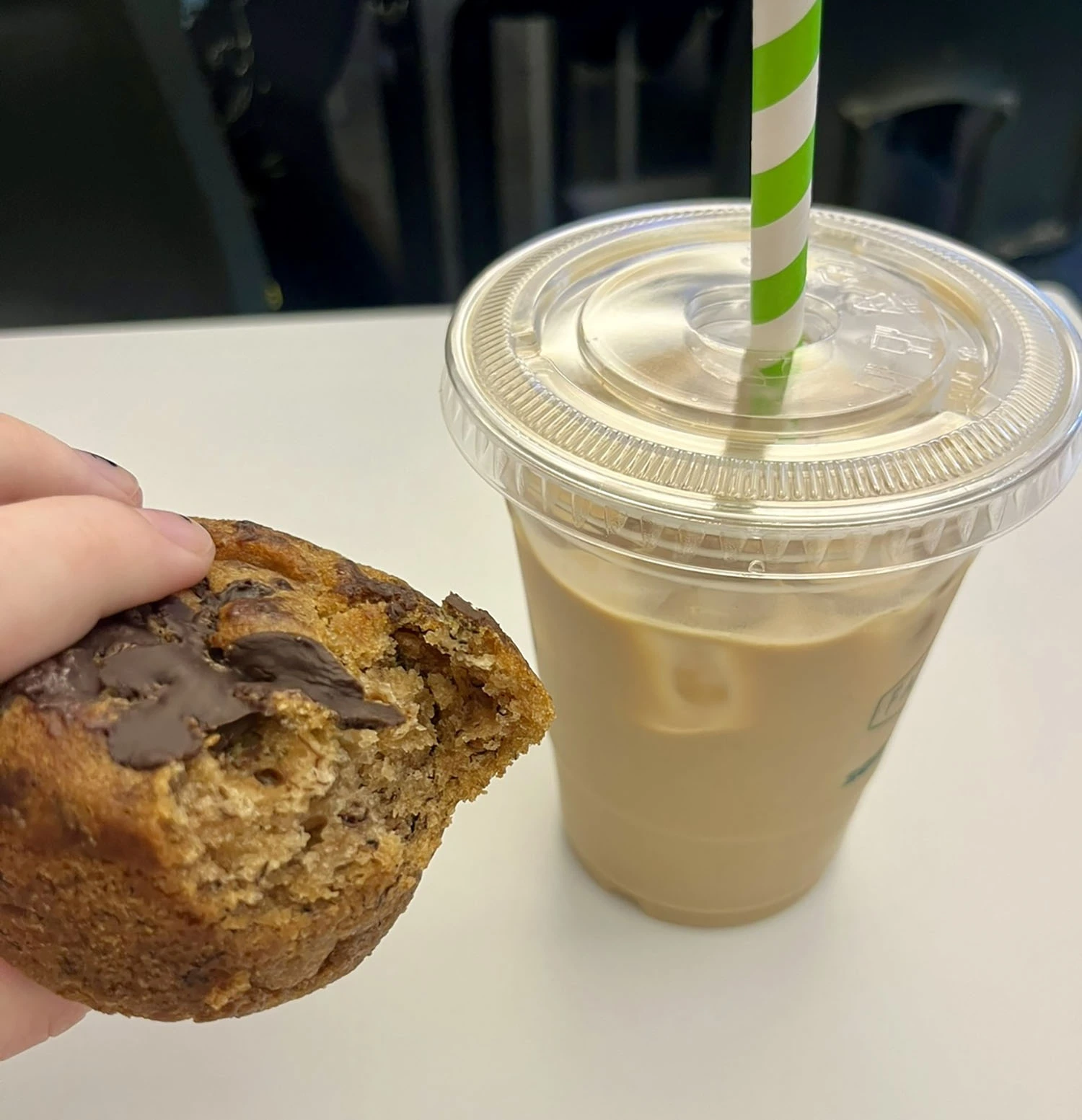 a muffin with a drink next to it