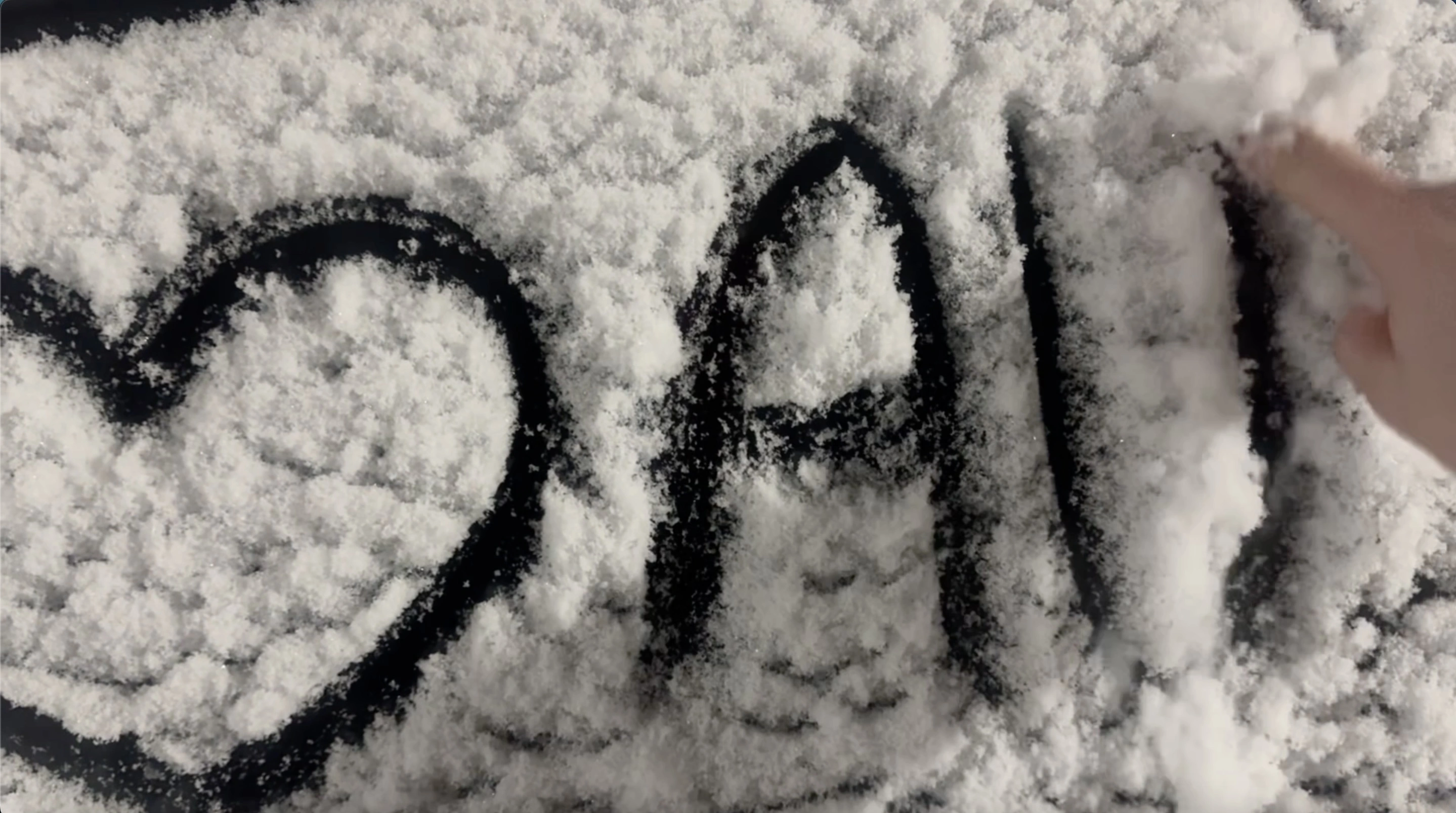 Handwriting in the snow showing heart shape next to AU