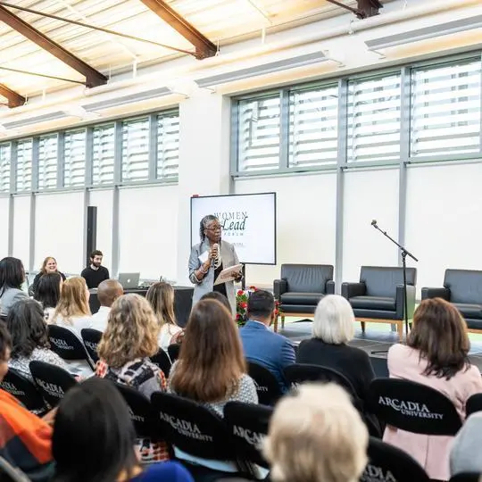 Brigette A. Bryant speaks before a group of women seated in chairs on the second floor of University Commons